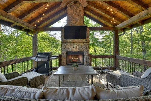 Main level porch with gorgeous year round views, fire place, TV, and outdoor seating