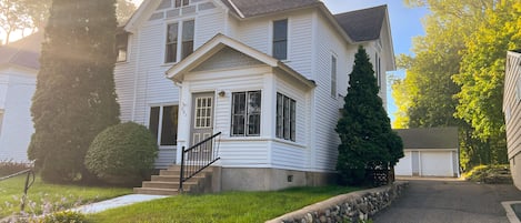 Front of house with driveway to back and garage