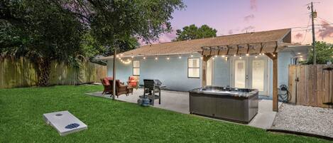 Back yard with hot tub, corn hill ,Edison light at night and seating area 