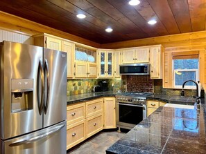 Kitchen with stainless appliances comes equipped with kitchen basics including Keurig coffee maker.