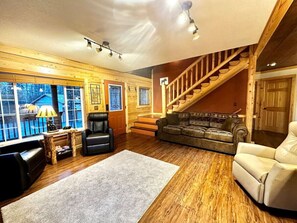 Living room shows front door and staircase to bedrooms upstairs.