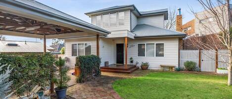 Front of property with lawn & carport