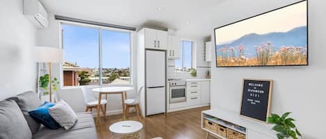 Living room & dining area with a wall mounted TV (with Netflix!) and beautiful views of Richmond