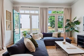 Open concept living area with large sectional and access to outdoor dining area.