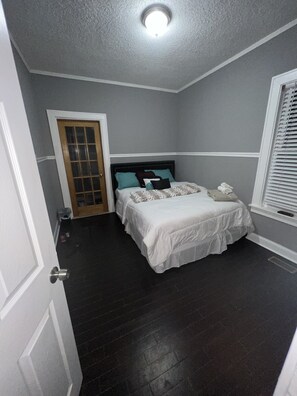 Bedroom 1 on the 1st floor with a queen bed and flat-screen TV. 