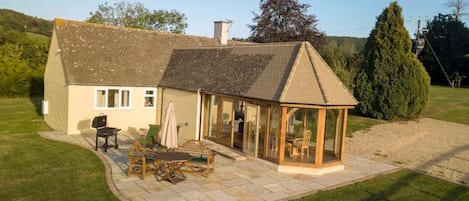 Private patio area with table benches and furniture. Charcoal BBQ.