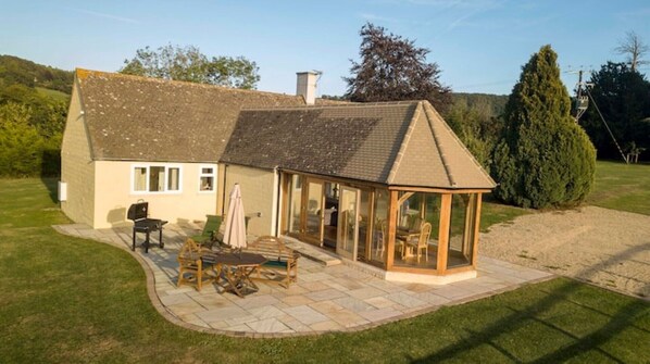 Private patio area with table benches and furniture. Charcoal BBQ.