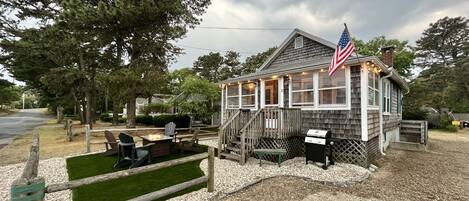 Turf yard, surrounded by sea shells. 4 Adirondack chairs, propane fire table.