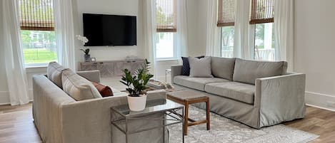 Living room features high ceilings and large windows to let in lots of light.