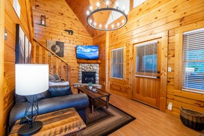 Main living area consisting of a queen sofa sleeper, love seat, fireplace & TV!