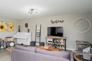 Relax in the spacious living room with comfortable armchairs and a cozy sofa.