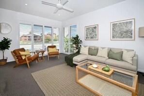 Lounge room, with pool and canal beyond. Lounge has smart TV 