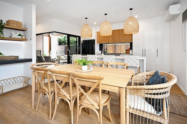 Dining room, with kitchen breakfast bar next to it and outdoor patio area beyond