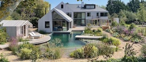 The award-winning house floats over a crystalline natural swimming pond