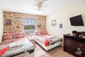 Bedroom 3 is a Route 66 themed-room with two double beds and a TV.