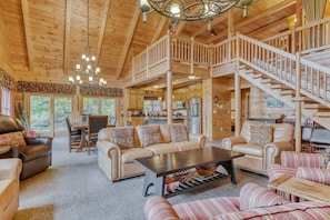 Living room area is filled with comfortable couches, chairs, and tables