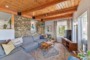 Living Room- Original rock wall, map of the lake and smart TV. 