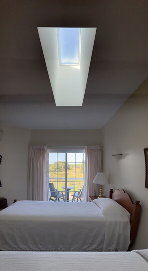 Guest bedroom, skylight above and private balcony looking up the peninsula towards Sally's Beach Provincial Park. Two single beds.