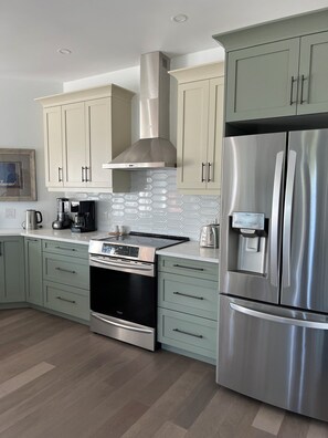 Spry 3 kitchen with indution range and exhaust hood.