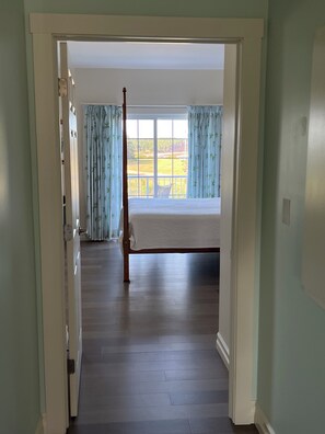 Master Bedroom with balcony and view directly to Sally's Beach Provincial Park. King size Tigerleaf maple pencil post bed.