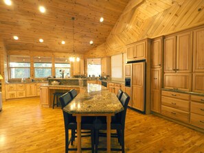 Kitchen island, granite counter tops, custom fridge and lots of pantry space.