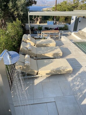 Sea view pool area with comfortable leather sunbeds with thick mattress.