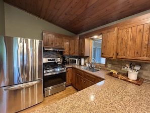 Full kitchen with cookware, grill gear, a griddle stove, oils and spices.