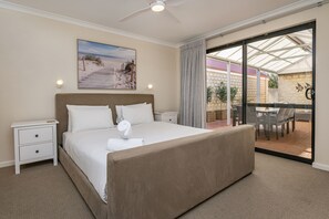Experience tranquillity in the first bedroom, featuring a plush king bed and direct access to the covered patio for peaceful mornings or evenings outdoors.