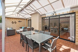 The spacious alfresco dining and lounge area, shaded under a high gabled roof, is perfect for outdoor meals and drinks.