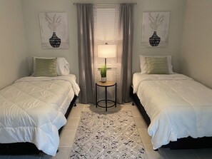 Bedroom with 2 twin beds and a night stand in between 