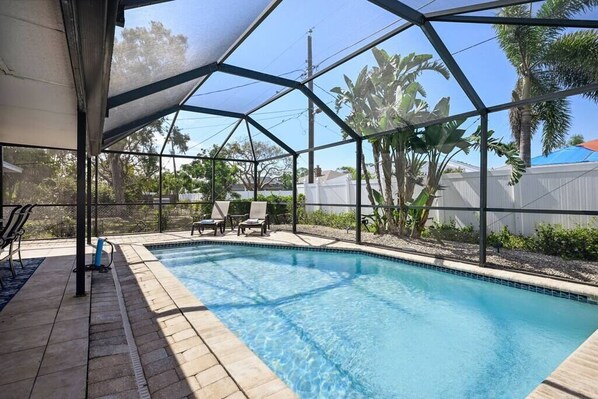 Large outdoor screened in area with outdoor dining, TV, sink, cold plunge