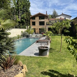 Vue sur la piscine et le jardin arboré 