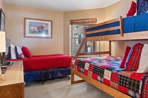 The guest bedroom provides extra sleeping space with a twin over queen bunk bed as well as a twin bed.