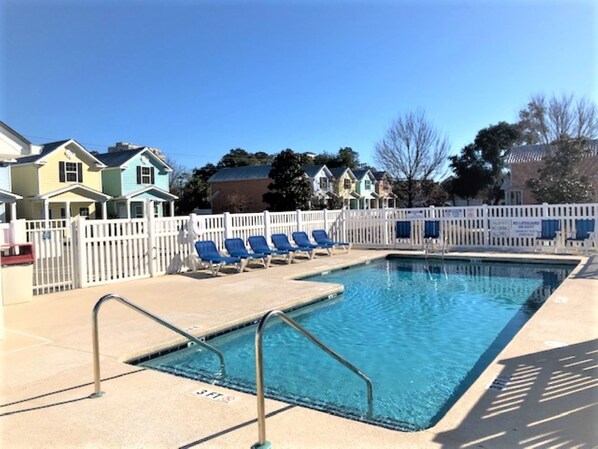 Heated outdoor pool area with clear skies and plenty of seating