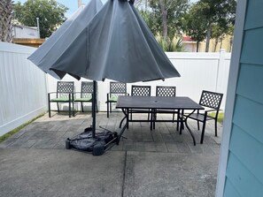 Peaceful fenced backyard with patio seating, perfect for relaxing outdoors