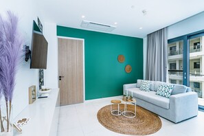 [Sophisticated Living Area of the Apartment in Noord Aruba - Natural light floods the room, enhancing its warmth and inviting atmosphere - Large Windows - Thoughtful mix of textures, from plush rugs to tasteful throw pillows