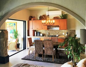 A large dining table is in the full kitchen.