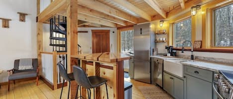 Beautiful kitchen with exposed wood beams, gorgeous hand crafted island, and new stainless steel appliances