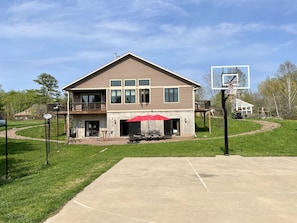Backyard with basketball halfcourt, fire pit grill and outdoor patio furniture. 