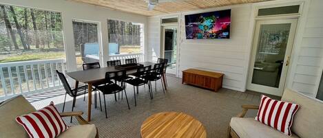 Large screened porch with smart TV and ample seating