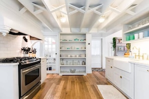 Kitchen with small pantry and stainless steel appliances.