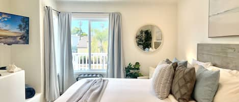 Serene primary bedroom, with king bed, partial ocean views and coastal decor.