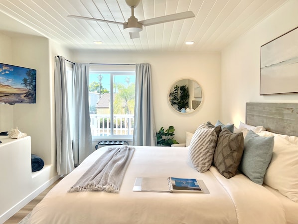 Serene primary bedroom, with king bed, partial ocean views and coastal decor.
