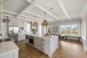 Large kitchen island is open to eating area and living room, with stellar views.