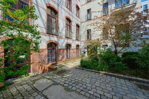 The entrance to a picturesque brick building surrounded by greenery.