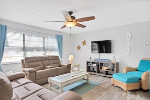 Living room with dual reclining sofas, 47" Smart/Roku TV with cable included.