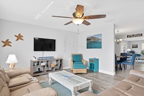Living room with dual reclining sofas, 47" Smart/Roku TV with cable included.