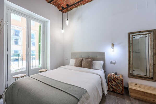 View of the bedroom with double bed and balcony