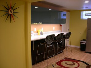 The dining counter features Mid-Century Bertoia style counter stools.