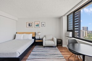 Room picture with view of Ala Wai Canal, queen bed, and dining t